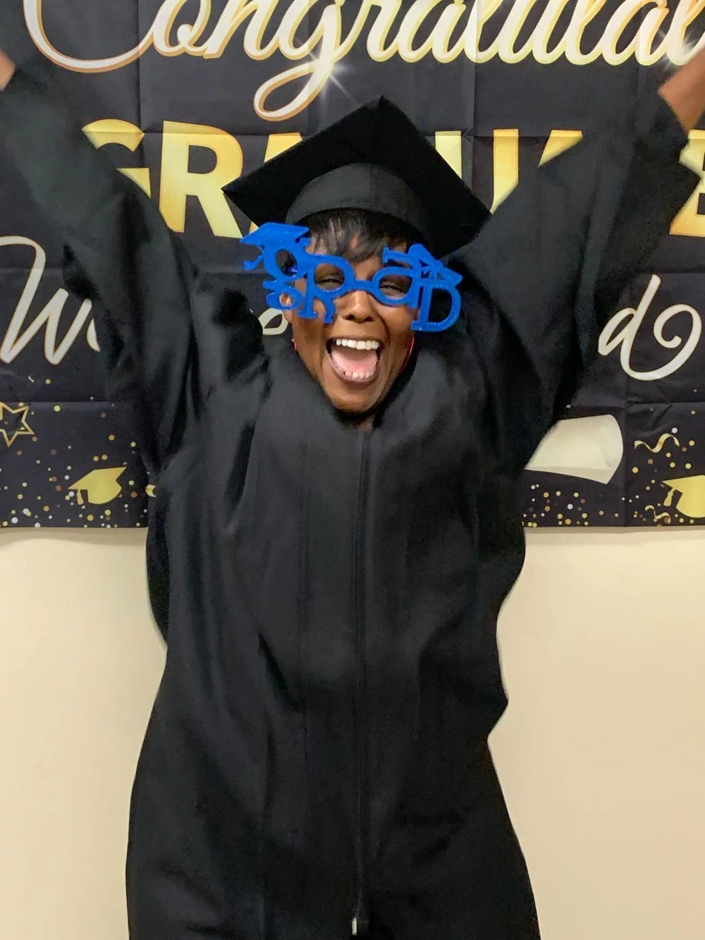 {{ school.name }} graduate showing excitement about completing the program
